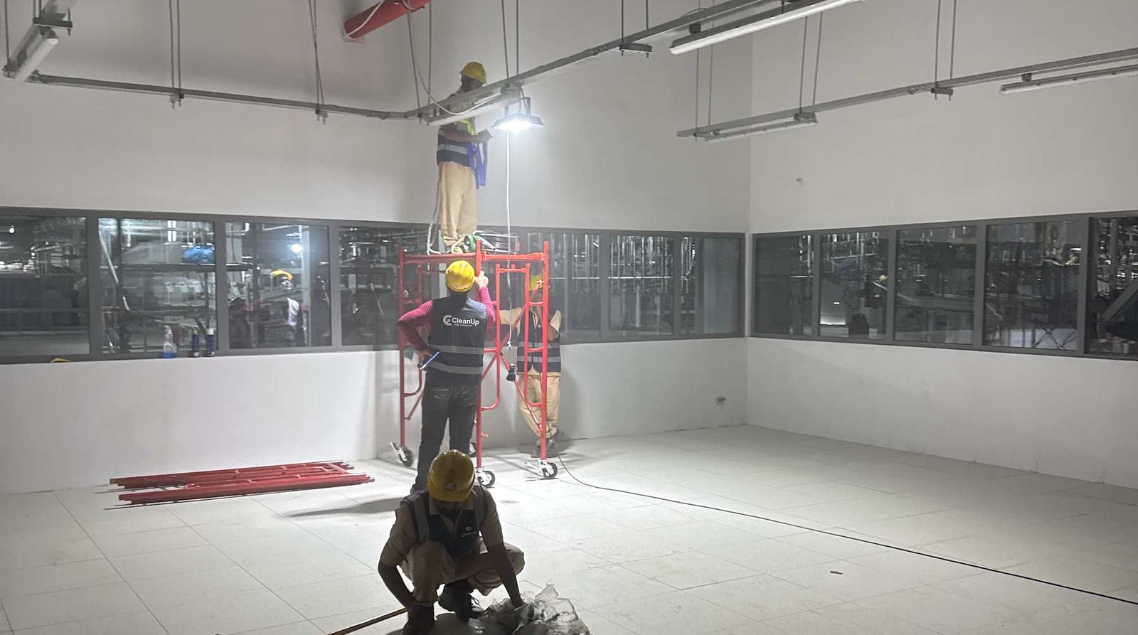 CleanUp crew cleaning a factory hall from a mobile scaffold